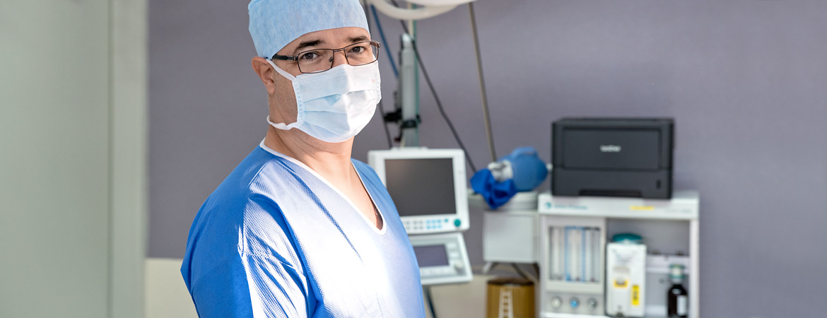 Dr. Sorin Radu en tenue et salle de chirurgie